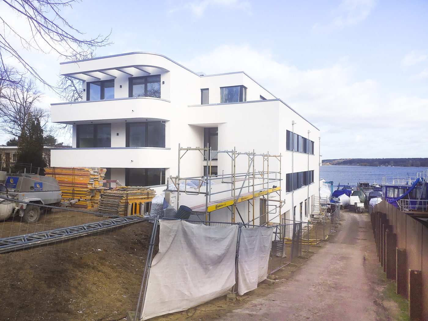 Weißes Mehrfamilienhaus am Wasser kurz vor der Fertigstellung